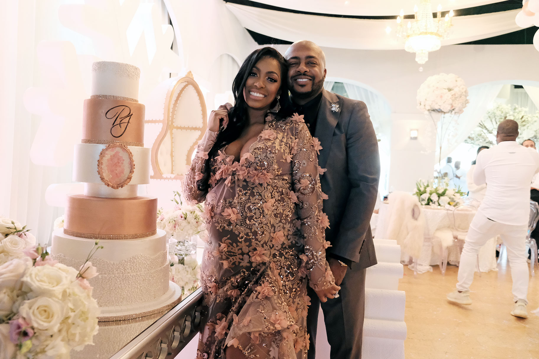 Porsha Williams and Dennis McKinley stand together in front of the cake during Porshas baby shower