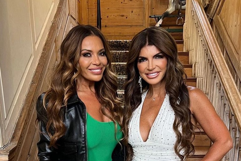 Dolores Catania and Teresa Giudice smiling in front of stairs.