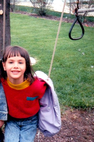 Kristen Doute smiles on a swing.