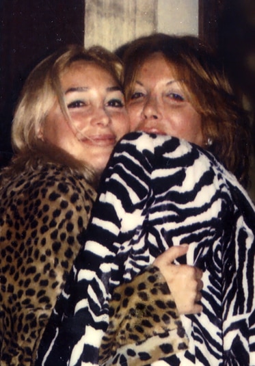 Elsa Patton wearing a zebra print top while hugging another woman.