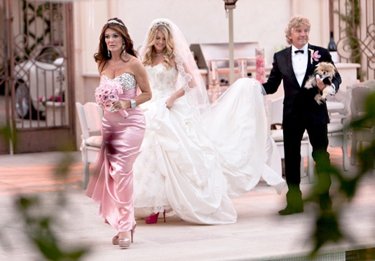 Pandora Vanderpump walking with Lisa Vanderpump and Ken Todd in her wedding gown.