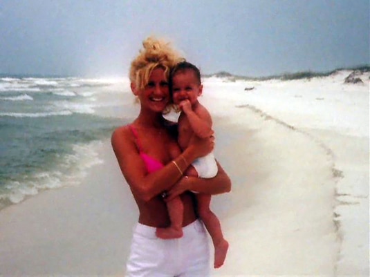 Kim Zolciak holding a baby on the beach