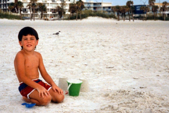 Tom Sandoval playing on the beach as a young child.