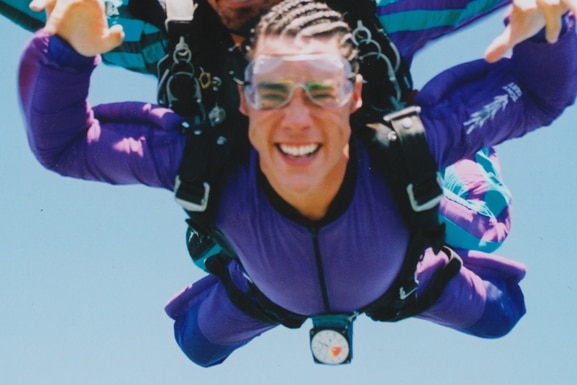 Tom Sandoval smiles while sky diving