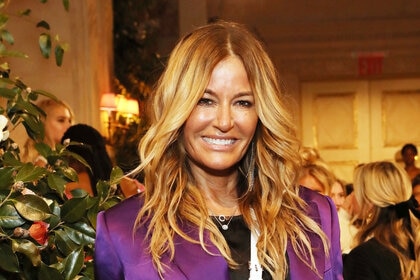 Kelly smiling in a purple blazer.