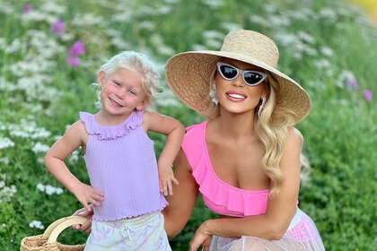 Gretchen Rossi and her daughter in a flower field outside together.