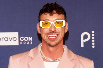 Kory Keefer smiling in front of a step and repeat at BravoCon 2023.