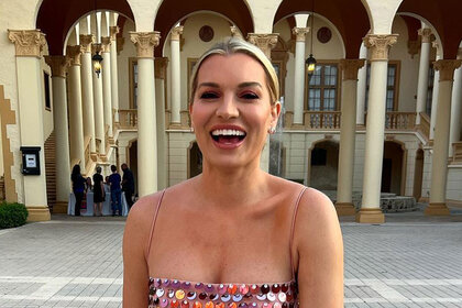 Lindsay Hubbard smiling and laughing in a pink, metallic, dress in Miami.