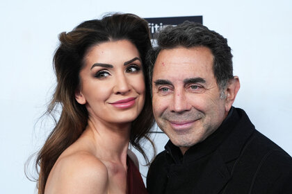 Paul Nassif and Brittany Nassif posing together in front of a step and repeat.
