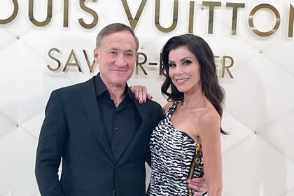 Heather Dubrow and Terry Dubrow posing in front of a step and repeat together.