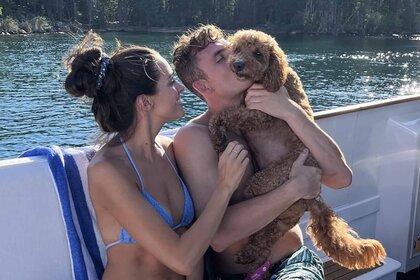 Vanderpump Rules' James Kennedy and Ally Lewber cuddle with their dog Hippie on a boat.