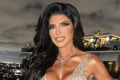 Teresa Giudice smiling in a gown and standing on a balcony.