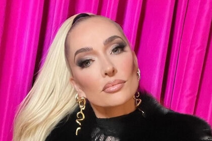 Erika Jayne posing in front of a pink curtain.