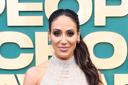 Melissa Gorga posing in front of a step and repeat.