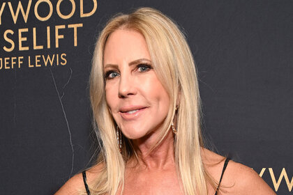 Vicki Gunvalson smiling in front of a step and repeat.