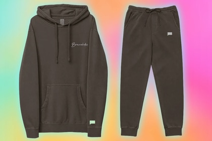 A sweatshirt and sweatpants in front of a colorful background.