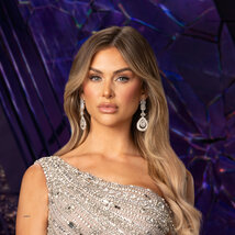 Lala Kent wearing a sparkly silver dress while in a purple room overlooking LA.