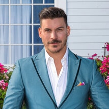 Jax Taylor wearing a blue suit on a grass lawn