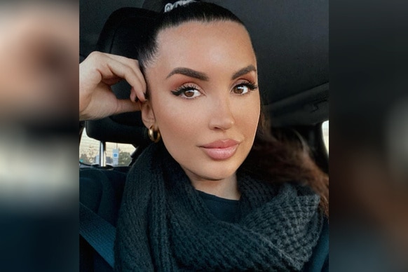 Ashlee Holmes wearing a black scarf while sitting in her car