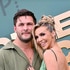 Scheana Shay and Brock Davies hugging and smiling in front of a step and repeat.