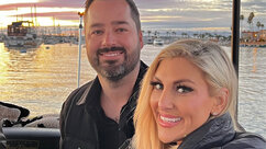 Gina Kirschenheiter and Travis Mullen smiling together on a boat during sunset.