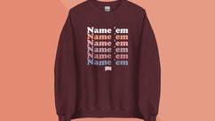 A brown sweatshirt with "Name 'em" repeated on it overlaid onto a colorful background.