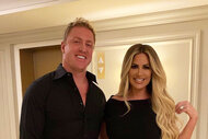Kim Zolciak-Biermann and Kroy Biermann posing and smiling together in all black outfits.