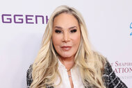 Adrienne Maloof posing in a tweed jacket in front of a step and repeat in Beverly Hills, California.