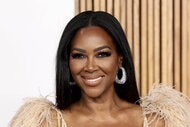 Kenya Moore wearing a feathered and crystal embellished dress at a red carpet event in New York City.