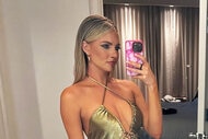 Taylor Ann Green wearing a metallic, cut out, halter dress and posing in a mirror.