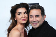 Paul Nassif and Brittany Nassif posing together in front of a step and repeat.