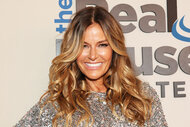 Kelly Bensimon posing in front of a step and repeat.