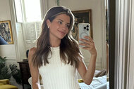 Naomie Olindo smiling in a mirror for a selfie.