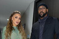 Larsa Pippen wears a green dress and stands next to Marcus Jordan who wears all black.