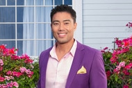 Jason Caperna wearing a purple suit in a grass lawn