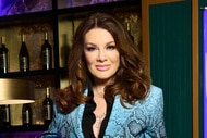 Lisa Vanderpump wearing a blue pattern blazer in front of a bar.