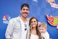 Brittany Cartwright, Jax Taylor, and Cruz Cauchi in front of a step and repeat.