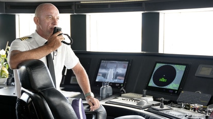 Captain Kerry Titheradge talking on his walkie talkie in the wheelhouse of the St. David yacht.