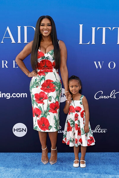 Kenya and Brooklyn in matching floral outfits on a step and repeat.