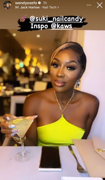 Wendy Osefo holds a cocktail while dining out.