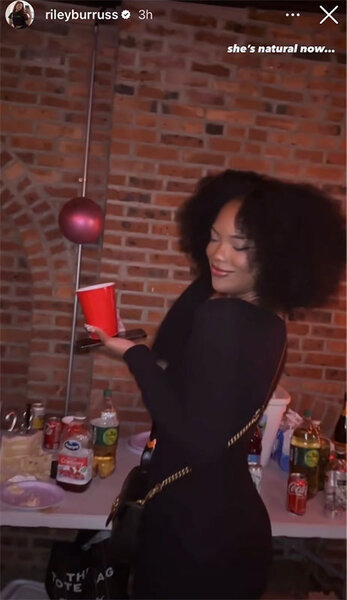 Riley Burruss posing in a black outfit with her natural hair texture at a party. Overlaid text: "She's natural now..."