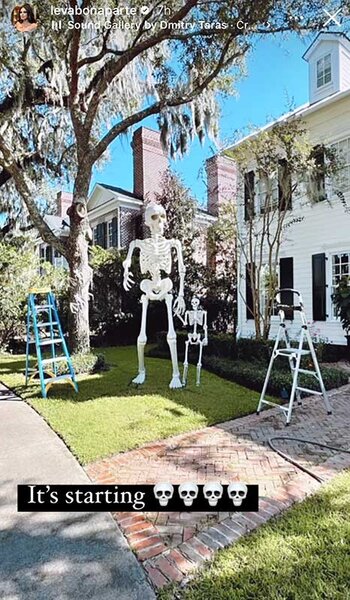 Leva Bonaparte shows her outdoor Halloween decor with giant skeletons. Overlaid text: "It's starting (4 skull face emojis)".