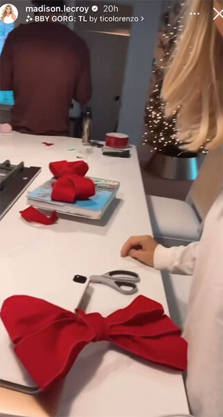 Madison LeCroy crafting a large red bow on a table.