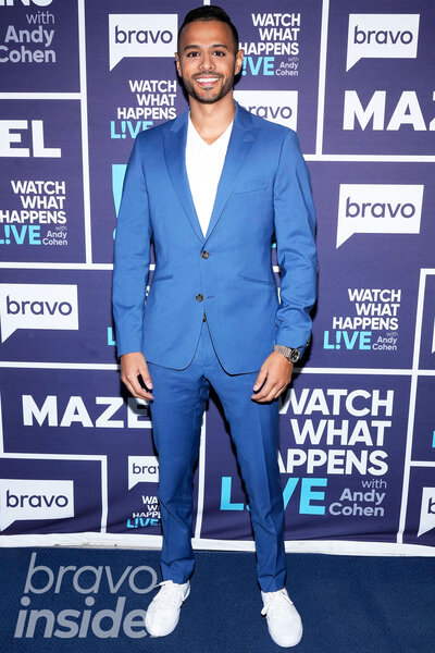 Brian Benni wearing a blue suit in front of a step and repeat at the Watch What Happens Live clubhouse in New York City.