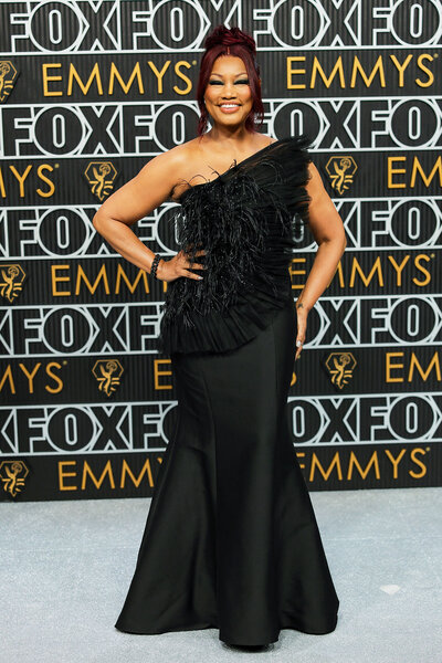 Garcelle Beauvais wearing a black, one shoulder, gown on the Emmys step and repeat.