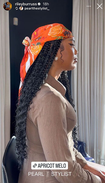 Riley Burruss sitting with a profile view of her outfit and hair.