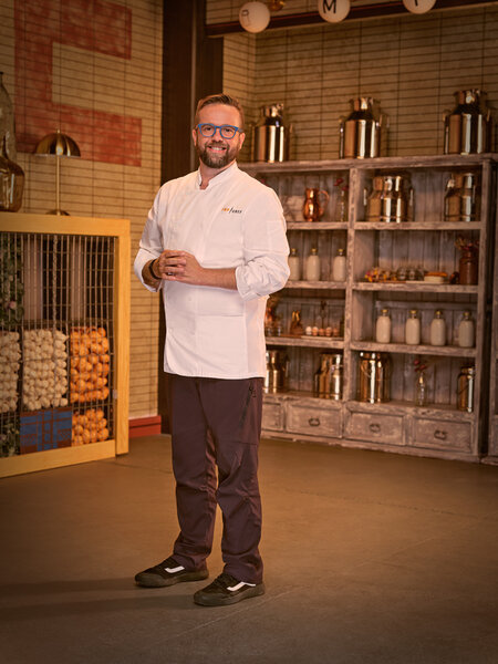 Full length of Daniel Jacobs in his chef's uniform in a kitchen pantry
