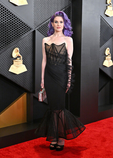 Full Length of Kelly Osbourne wearing a black gown on the red carpet for 66th GRAMMY Awards