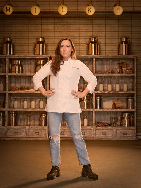 Full length of Savannah Miller in her chef's uniform in a kitchen pantry