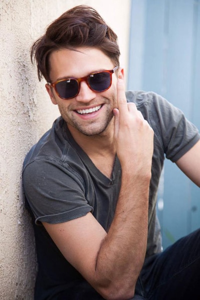 Tom Schwartz smiling in a pair of sunglasses and a grey t-shirt